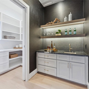 Textured wet bar with floating shelves and brass fixtures