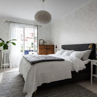 Foto på ett nordiskt huvudsovrum, med vita väggar, ljust trägolv och beiget golv