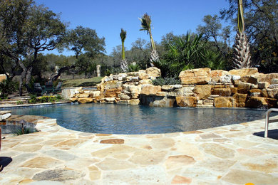 Mid-sized island style stone and custom-shaped pool fountain photo in Other