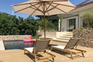 Réalisation d'une piscine arrière design de taille moyenne avec une terrasse en bois.