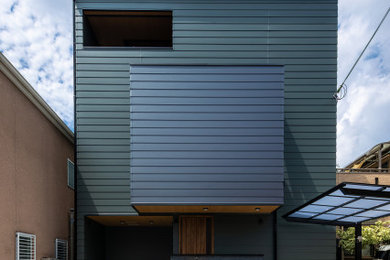 Foto de fachada de casa verde de dos plantas con tejado de un solo tendido y tejado de metal