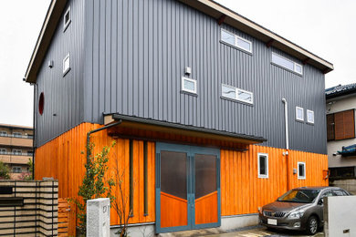 Imagen de fachada de casa gris de estilo americano pequeña de dos plantas con tejado de un solo tendido y tejado de metal