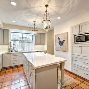 Неиссякаемый источник вдохновения для домашнего уюта: огромная п-образная кухня в стиле современная классика с кладовкой, врезной раковиной, фасадами с утопленной филенкой, серыми фасадами, столешницей из оникса, желтым фартуком, техникой из нержавеющей стали, полом из терракотовой плитки, двумя и более островами, разноцветным полом и белой столешницей