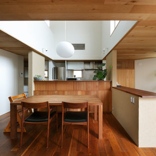 Offenes Modernes Esszimmer mit weißer Wandfarbe, dunklem Holzboden und rosa Boden in Sonstige