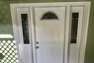 Example of a small classic carpeted and gray floor entryway design in San Francisco with green walls and a white front door