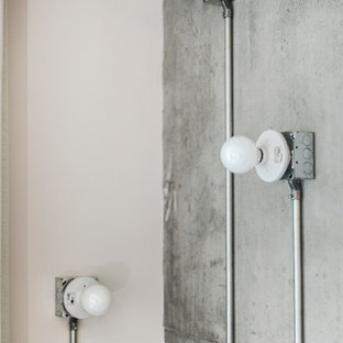 Immagine di un piccolo soggiorno industriale stile loft con nessun camino, sala formale, TV a parete e pareti grigie