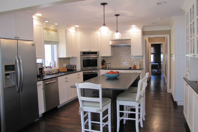 Mid-sized transitional u-shaped eat-in kitchen in New York with an undermount sink, shaker cabinets, beige cabinets, granite benchtops, beige splashback, porcelain splashback, stainless steel appliances, dark hardwood floors and with island.