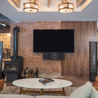 カンザスシティの中サイズのラスティックスタイルのおしゃれな地下室 (半地下 (ドアあり)、コンクリートの床、薪ストーブ、茶色い床) の写真