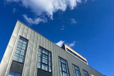 Immagine della facciata di un appartamento grande grigio moderno a quattro piani con rivestimento in metallo e pannelli e listelle di legno