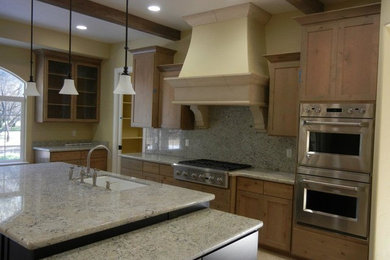 Open concept kitchen - large traditional l-shaped limestone floor and beige floor open concept kitchen idea in Sacramento with an undermount sink, shaker cabinets, medium tone wood cabinets, granite countertops, gray backsplash, stone slab backsplash, stainless steel appliances and an island
