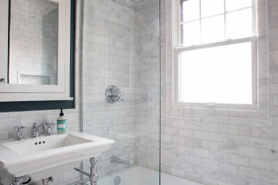 Small classic shower room bathroom in Minneapolis with a built-in bath, a shower/bath combination, a one-piece toilet, white tiles, marble tiles, marble flooring, a console sink, white floors, a shower bench, a single sink and wainscoting.