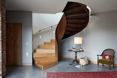 Diseño de escalera curva marinera con escalones de madera, contrahuellas de madera y barandilla de metal