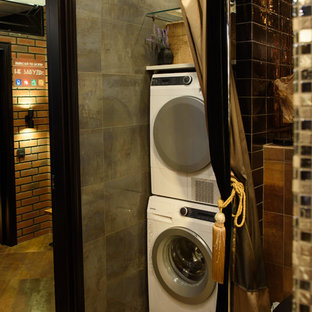 Photo of an industrial laundry cupboard in Moscow with grey walls, a stacked washer and dryer and orange floors.
