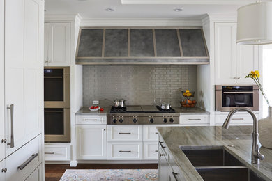 Mid-sized transitional u-shaped dark wood floor and brown floor open concept kitchen photo in Chicago with an undermount sink, shaker cabinets, white cabinets, gray backsplash, stainless steel appliances, an island, marble countertops, ceramic backsplash and beige countertops