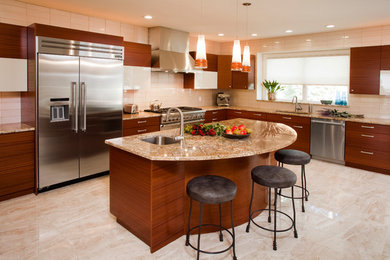 Trendy l-shaped beige floor kitchen photo in Philadelphia with an undermount sink, flat-panel cabinets, medium tone wood cabinets, beige backsplash, glass tile backsplash, stainless steel appliances, an island and beige countertops