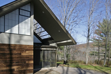 This is an example of a mid-sized modern one-storey grey exterior in New York with mixed siding.
