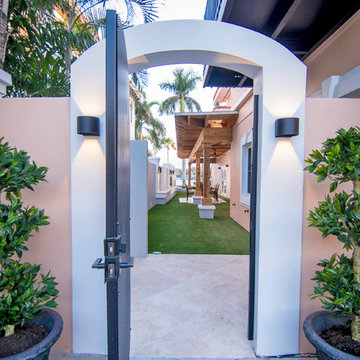 Walled-in outdoor covered lanai with custom fireplace and artificial greens