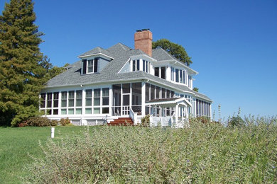 Large elegant blue two-story wood exterior home photo in Baltimore with a shingle roof