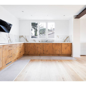 Agencement d'une grande cuisine équipée moderne tendance en L bois et blanche.