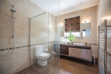 Modern family bathroom in Other with flat-panel cabinets, brown cabinets, a walk-in shower, a one-piece toilet, beige tiles, an open shower, double sinks and a floating vanity unit.