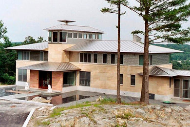 Example of a large trendy beige two-story stone exterior home design in Boston with a hip roof