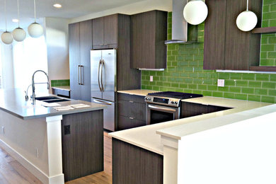 Inspiration for a mid-sized 1960s l-shaped light wood floor kitchen remodel in Denver with a double-bowl sink, flat-panel cabinets, dark wood cabinets, green backsplash, ceramic backsplash, stainless steel appliances and an island