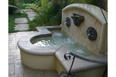 Example of a tuscan side yard stamped concrete patio fountain design in Los Angeles with no cover