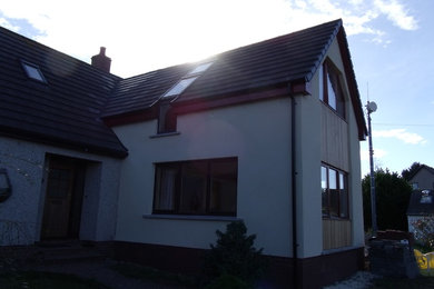 Imagen de fachada de casa blanca campestre de tamaño medio de dos plantas con revestimiento de estuco, tejado a dos aguas y tejado de teja de barro