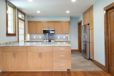 Inspiration for a small transitional galley medium tone wood floor and gray floor eat-in kitchen remodel in Baltimore with an undermount sink, flat-panel cabinets, light wood cabinets, granite countertops, blue backsplash, porcelain backsplash, stainless steel appliances, a peninsula and gray countertops