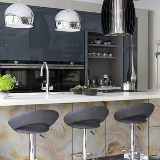 Large contemporary kitchen pantry photos - Inspiration for a large contemporary galley porcelain floor and gray floor kitchen pantry remodel in Hertfordshire with an undermount sink, flat-panel cabinets, distressed cabinets, quartzite countertops, black appliances, an island and white countertops