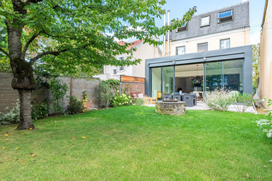Exemple d'un jardin à la française arrière tendance de taille moyenne avec une exposition partiellement ombragée et une clôture en métal.