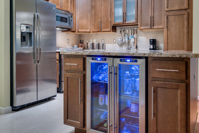Inspiration for a small transitional l-shaped porcelain tile eat-in kitchen remodel in DC Metro with an undermount sink, shaker cabinets, dark wood cabinets, granite countertops, beige backsplash, stone tile backsplash, stainless steel appliances and an island