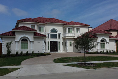 Photo of a large traditional two-storey stucco white house exterior in Dallas with a hip roof and a tile roof.