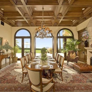 Пример оригинального дизайна: огромная гостиная-столовая в средиземноморском стиле с бежевыми стенами, стандартным камином, фасадом камина из камня, мраморным полом и коричневым полом