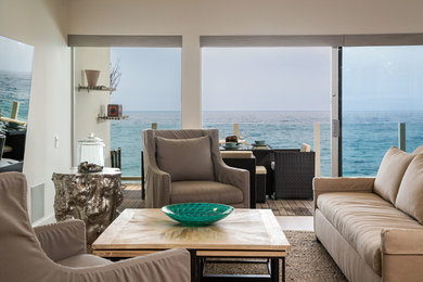 Living room - large coastal formal and loft-style medium tone wood floor living room idea in Los Angeles with beige walls, no fireplace and a wall-mounted tv