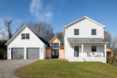 Cottage white two-story house exterior photo in Burlington with a metal roof and a black roof