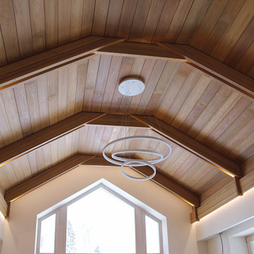 Просторная спальня в доме с деревянным потолком