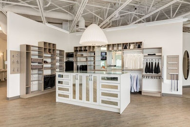 Walk-in closet - large gender-neutral brown floor walk-in closet idea in Calgary