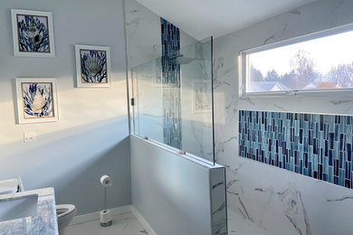 Example of a mid-sized beach style 3/4 multicolored tile multicolored floor and double-sink open shower design in Cleveland with white cabinets, a two-piece toilet, green walls, gray countertops, a built-in vanity, shaker cabinets and quartzite countertops