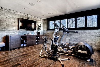 Inspiration for a large contemporary multipurpose gym in Orange County with medium hardwood floors, grey walls and brown floor.