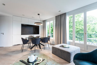 Aménagement d'une petite salle de séjour moderne ouverte avec un mur blanc, parquet clair et un sol beige.