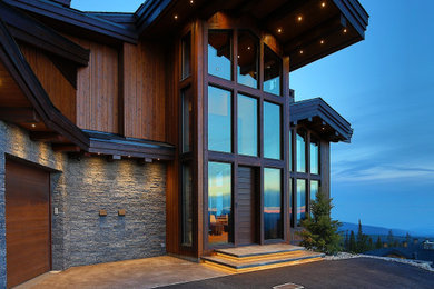 Mountain style multicolored three-story mixed siding and board and batten house exterior photo in Other