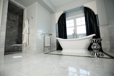 Design ideas for a large transitional master bathroom in Chicago with a freestanding tub, stone tile, marble floors, a curbless shower, gray tile, grey walls, raised-panel cabinets, white cabinets, an undermount sink, marble benchtops and grey floor.