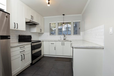 Example of a mid-sized minimalist u-shaped porcelain tile kitchen design in Vancouver with a single-bowl sink, shaker cabinets, white cabinets, granite countertops, white backsplash, subway tile backsplash and stainless steel appliances