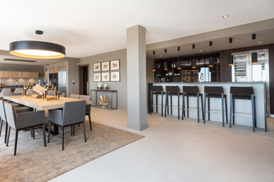 Inspiration pour une très grande salle de séjour design ouverte avec un bar de salon, un mur beige, un sol en carrelage de céramique et un sol beige.