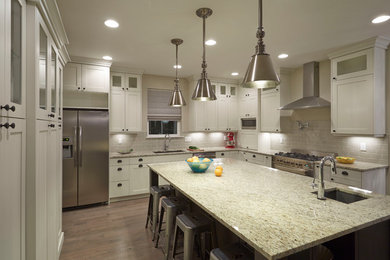 Example of a large transitional u-shaped medium tone wood floor eat-in kitchen design in Denver with an undermount sink, shaker cabinets, white cabinets, laminate countertops, green backsplash, ceramic backsplash, stainless steel appliances and an island