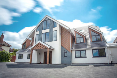 Large and white contemporary detached house in Other with three floors, a pitched roof, a tiled roof and a grey roof.