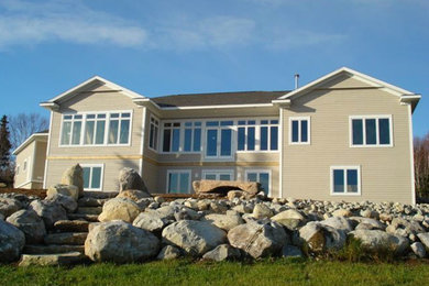 Large traditional beige two-story wood exterior home idea in Other