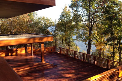 Deck - large contemporary backyard deck idea in New York with a roof extension