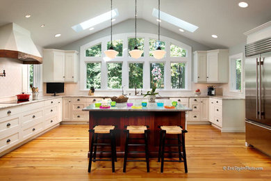 Inspiration for a transitional u-shaped kitchen remodel in DC Metro with shaker cabinets, white cabinets, marble countertops, white backsplash, subway tile backsplash, stainless steel appliances and an island
